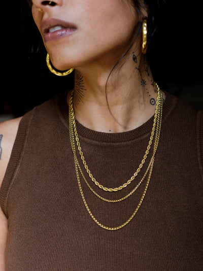 Unisex wheat chain handcrafted in brass. 1 micron gold plated necklace suited for men and women. Designed in Goa and handmade in Jaipur. Armeen layers the Tonca Chromosome Chain, Moira Box Chain and Aldona Chain. 