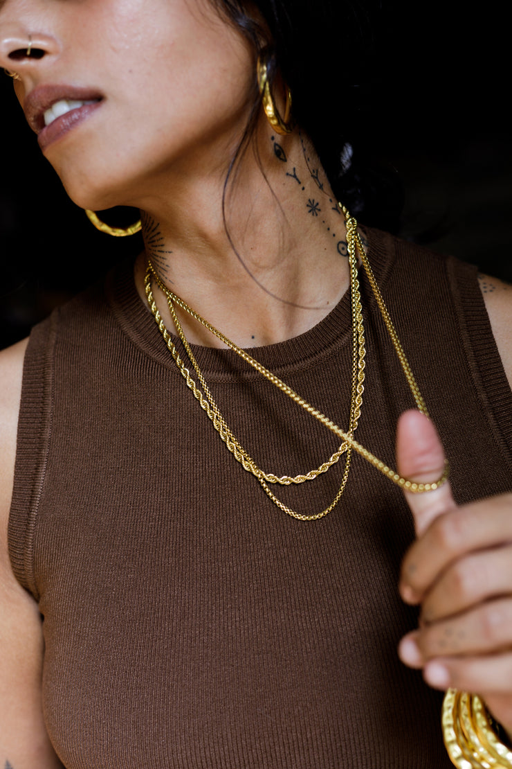Unisex rope chain handcrafted in brass. 1 micron gold plated necklace suited for men and women. Designed in Goa and handmade in Jaipur. Armeen layers the Tonca Chromosome Chain, Moira Box Chain and Aldona Chain. 