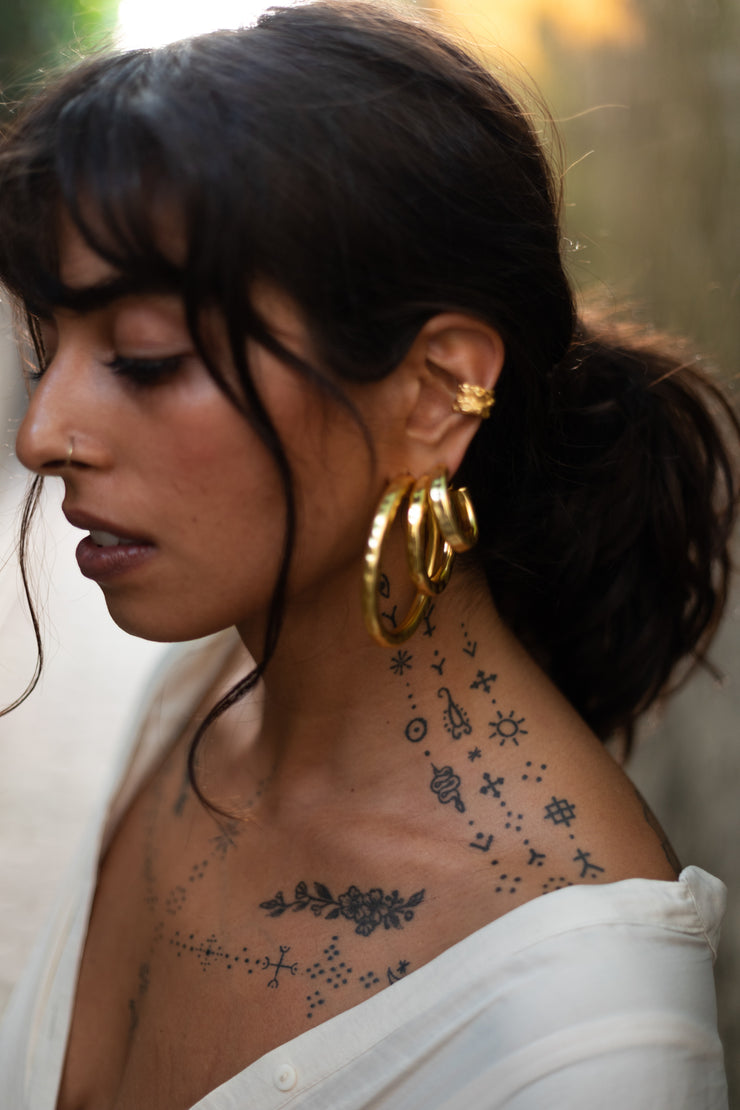 Lightly hammered ripple textured brass with ( one ) 1 micron gold plated medium hoops. Chunky textured hoops that are light-weight and 90s inspired. AM to PM hoops suited for every occasion. Available in 3 ( three ) sizes - small, medium and big.  Armeen wears all three ( 3 ) sizes.